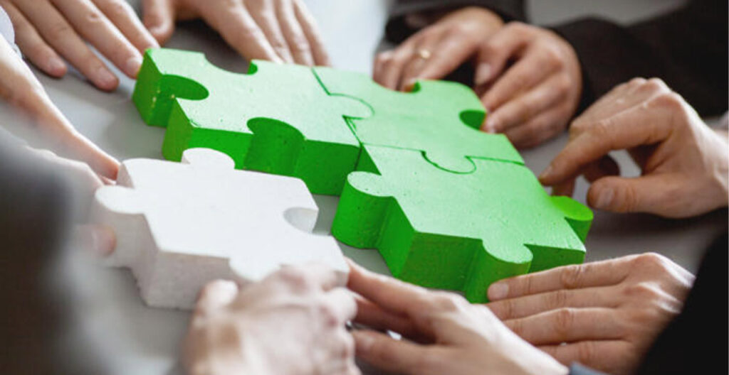 Business people putting together a puzzle as partners